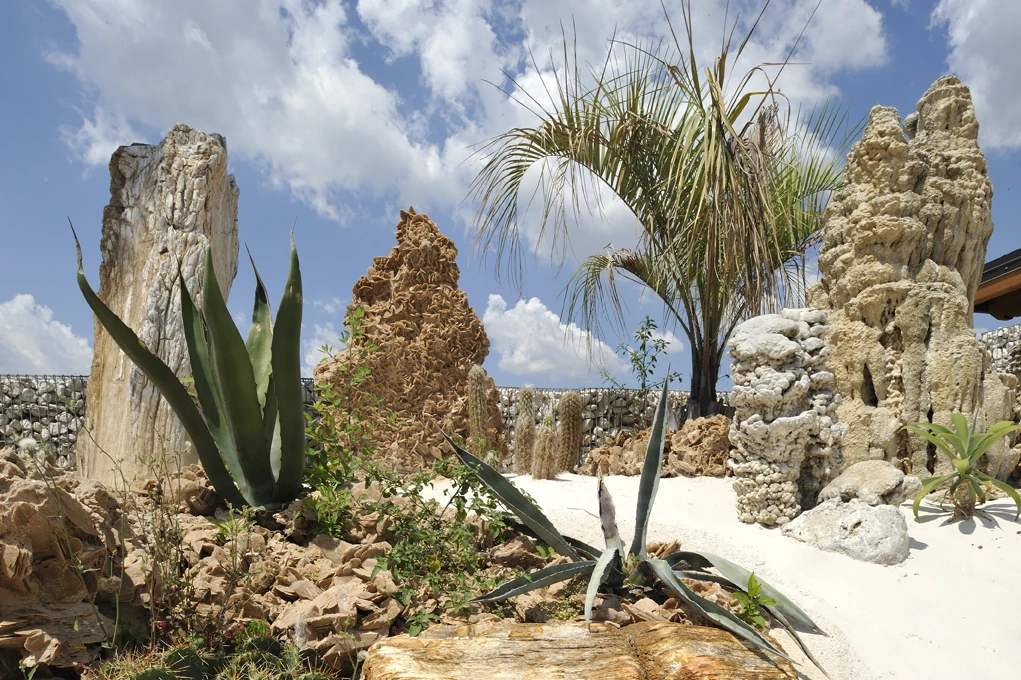 Unikatowe monolity kamienne Red Spaghetti i Pipeline na tle jasnego piasku w ogrodzie w stylu Desert Zen.webp